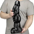 Czarne monster dildo z łuskową fakturą — wariant czarny w dłoniach